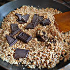 Шоколад разломать на кусочки и смешать с горячими орехами, дать растаять. Добавить щепотку соли и 2 ч. л. сахара, перемешать.