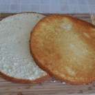 Остывший белый бисквит разрезать вдоль на два коржа.